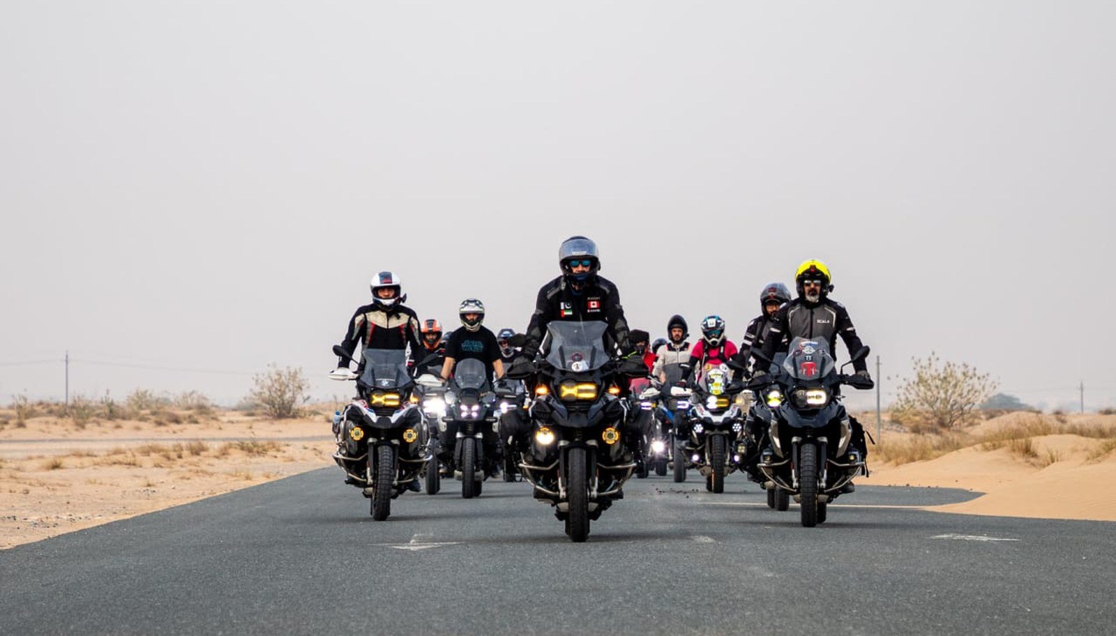 Group of riders on a UAE desert road — Group Riding Hand Signals